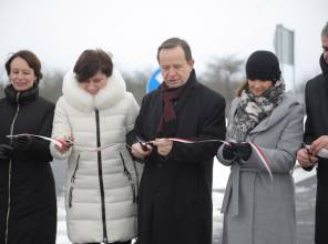 Symboliczne otwarcie drogi - zdjęcie przedstawia uczestników wydarzenia przecinających wstęgę